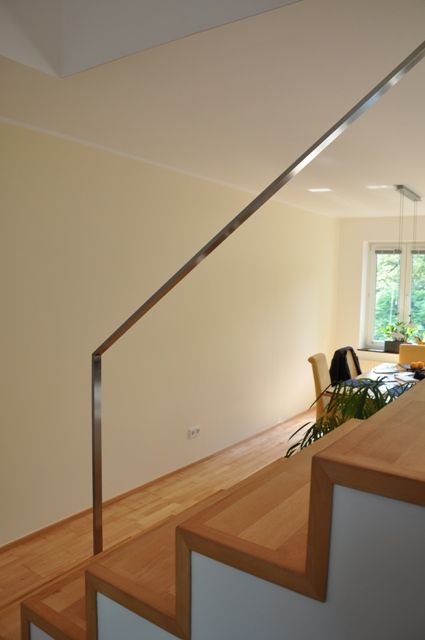 Eine Treppe mit Edelstahlgeländer, die zu einem Wohnzimmer führt