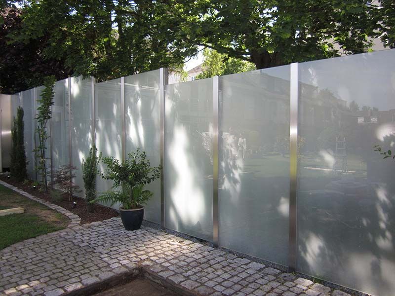 Ein Glaszaun mit einer Topfpflanze davor