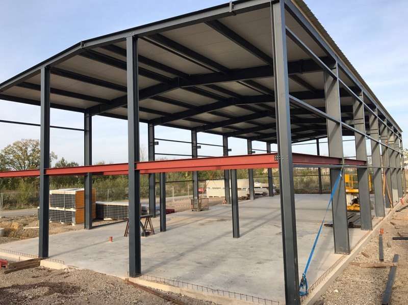 Es wird eine große Metallkonstruktion mit Betonboden errichtet.