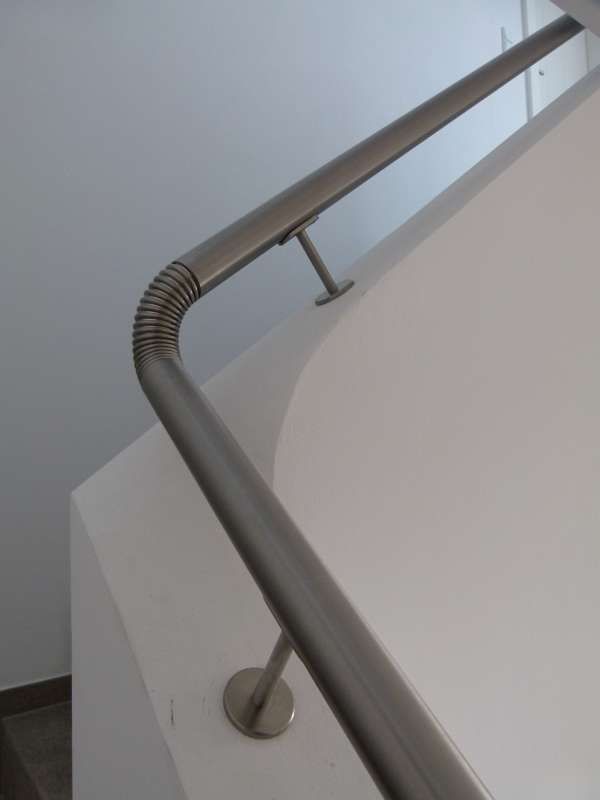 Eine Nahaufnahme von einem Edelstahlgeländer auf einer Treppe