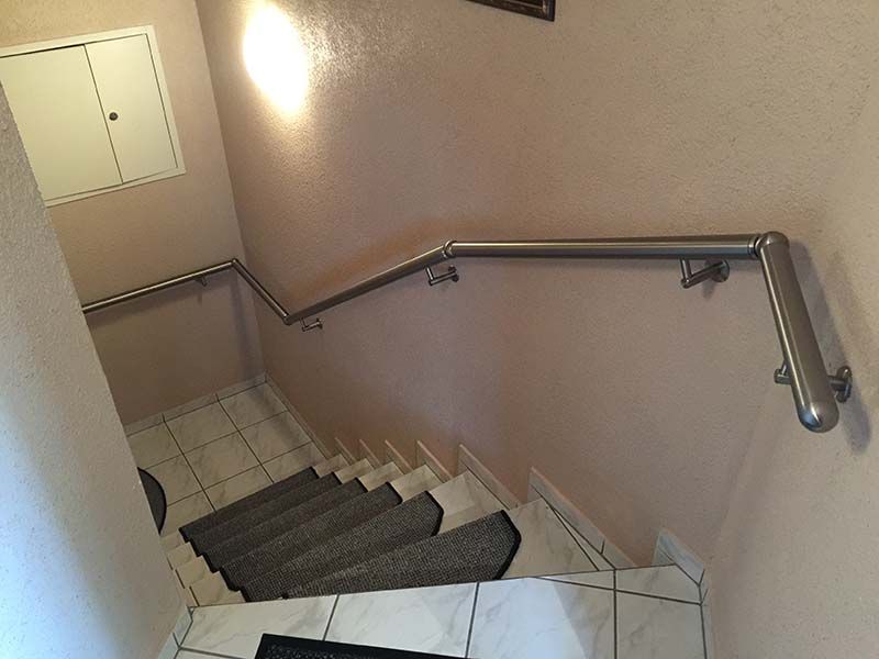 Eine Treppe mit Edelstahlgeländer und eine mit Teppich ausgelegte Treppe.