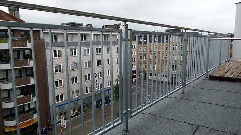 Ein Balkon mit einem Metallgeländer mit Blick auf eine Stadt
