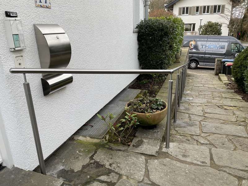 An der Seite eines Gebäudes wird ein Edelstahlgeländer angebracht.