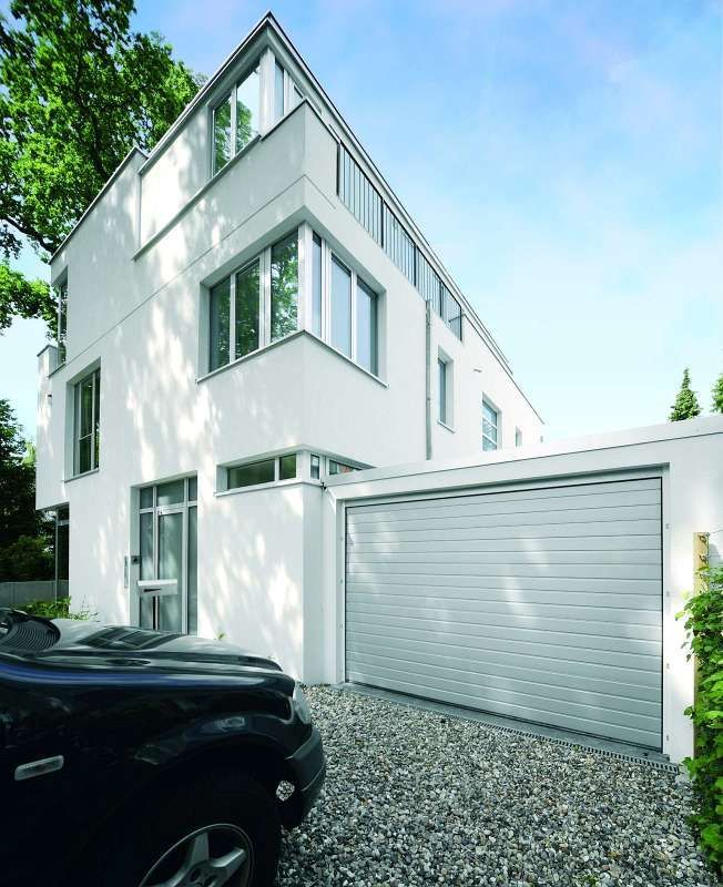 Ein schwarzes Auto steht vor einem weißen Haus