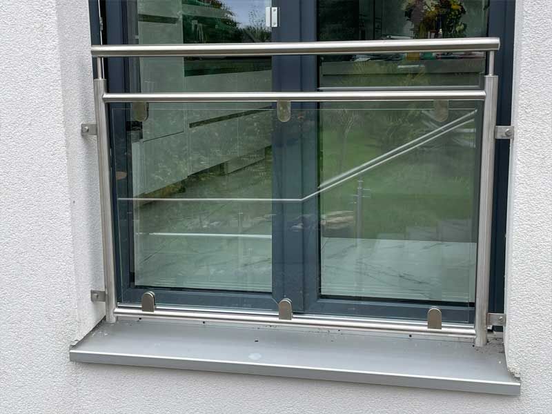 Ein Fenster mit einem Edelstahlgeländer daran.