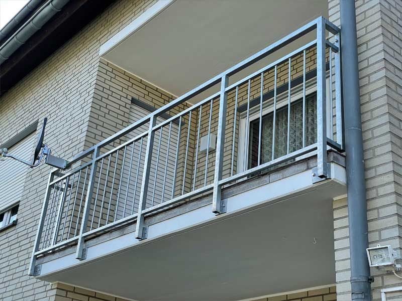 Ein Balkon mit einem Metallgeländer an der Seite eines Backsteingebäudes.