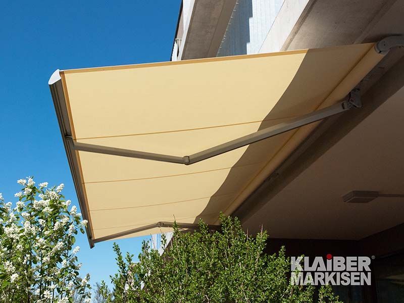 Eine gelbe Markise befindet sich an der Seite eines Gebäudes