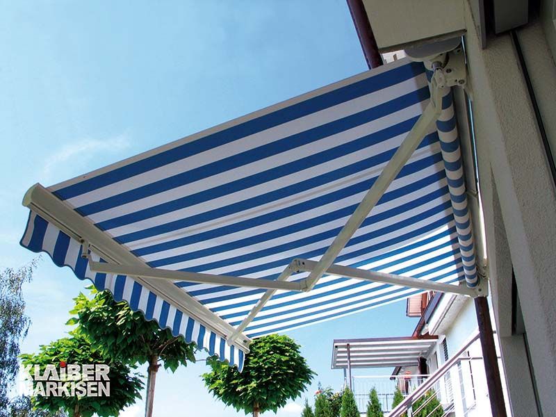 Eine blau-weiß gestreifte Markise befindet sich an der Seite eines Gebäudes