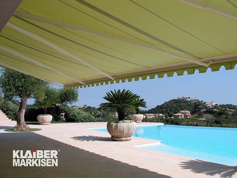 Ein Swimmingpool mit einer grünen Markise darüber
