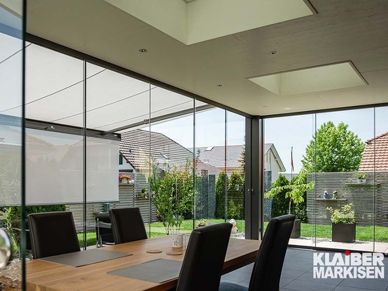 Ein Esszimmer mit Tisch und Stühlen und einem großen Fenster.