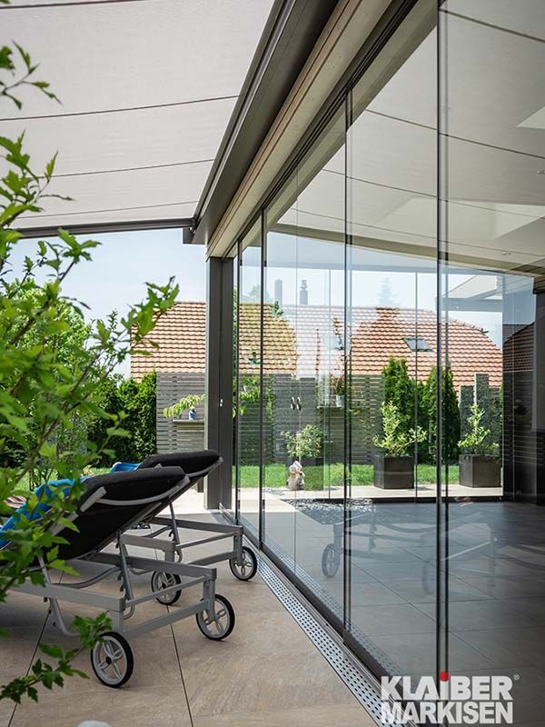 Eine Terrasse mit Glasschiebetür und Liegestuhl