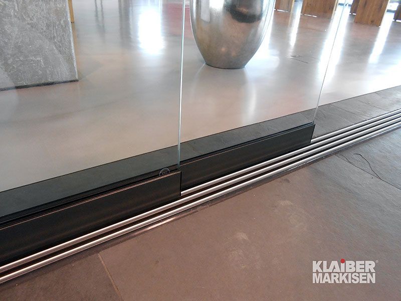 Eine Glasschiebetür mit Edelstahlgeländer am Boden.