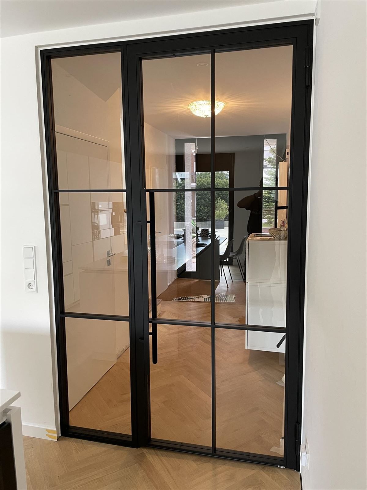 Ein Raum mit einer Glasschiebetür, die zum Wohnzimmer führt.