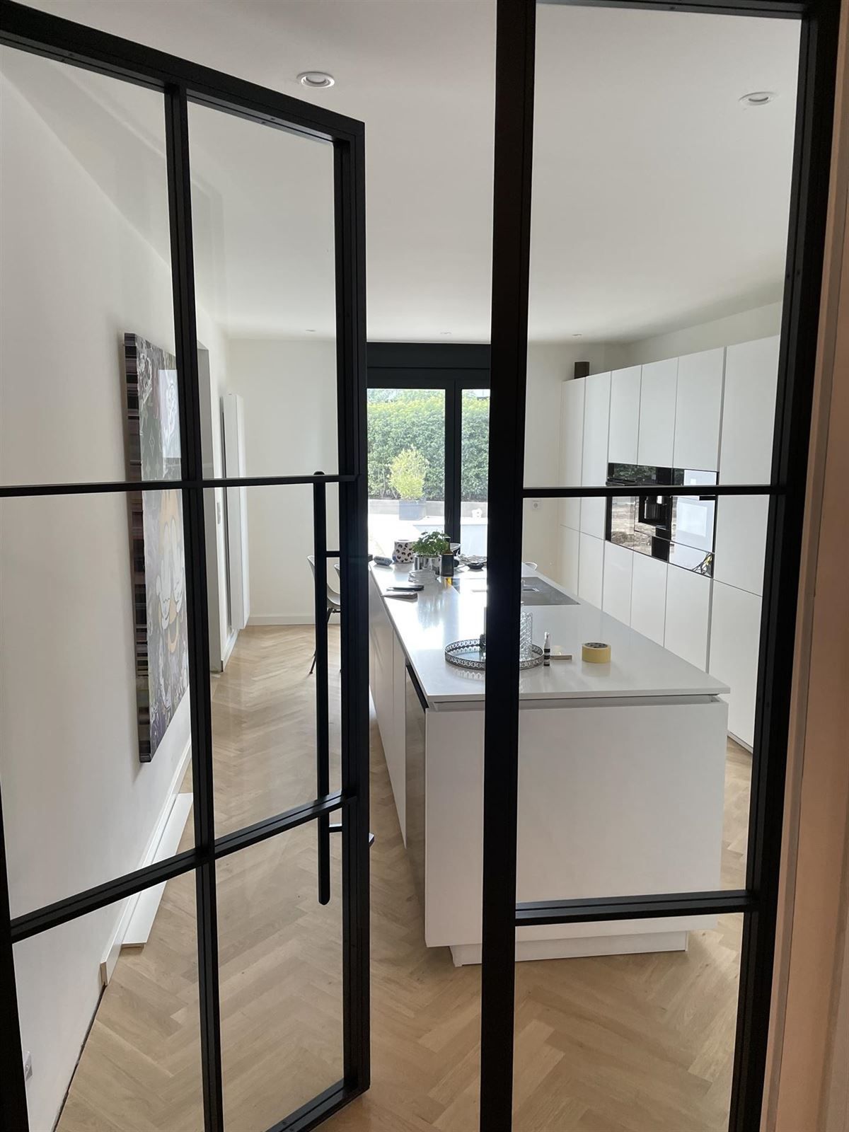 Ein Blick in eine Küche durch eine Glastür.