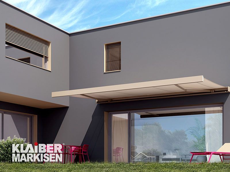 Ein graues Haus mit einer weißen Markise an der Seite