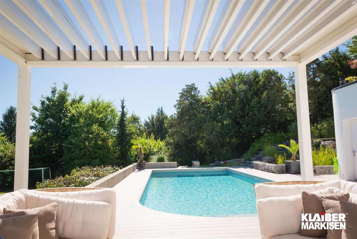 Ein Swimmingpool mit einer weißen Pergola darüber