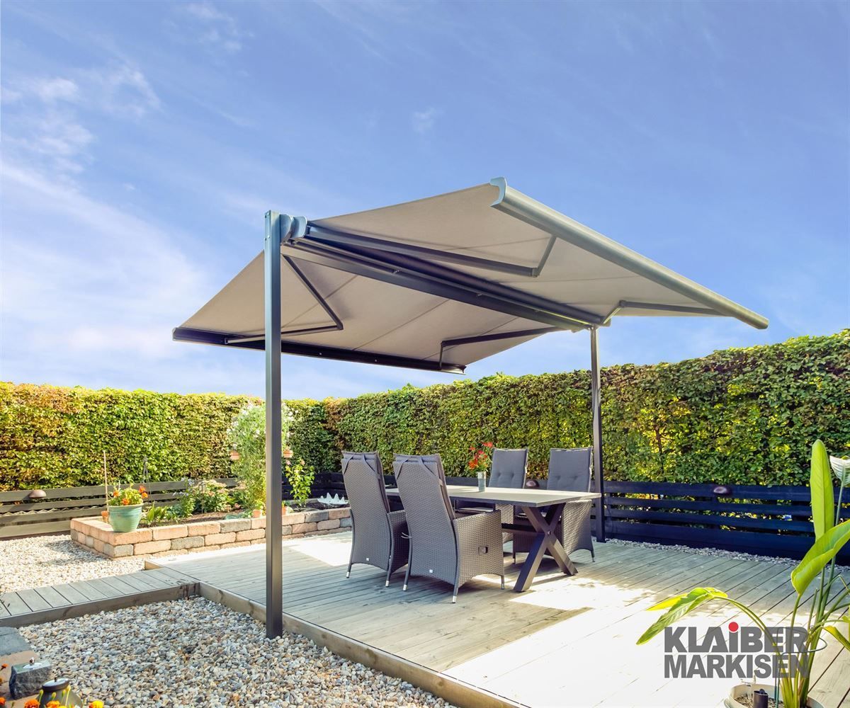 Eine Terrasse mit Tisch und Stühlen unter einer Markise mit der Aufschrift „Klaiber Markise“