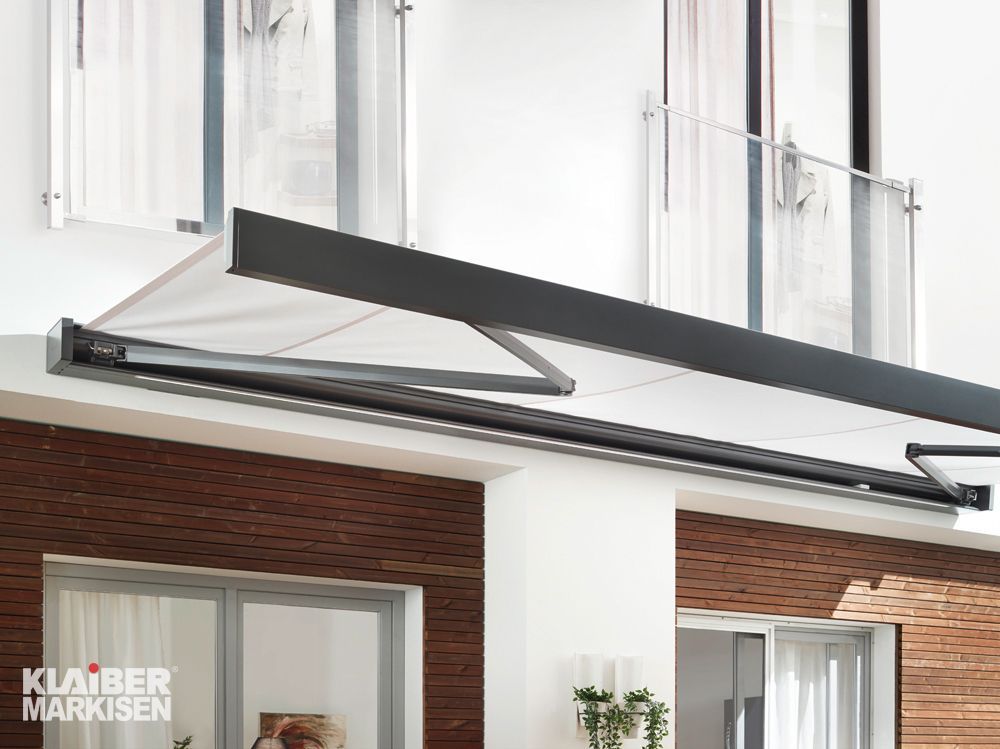 Ein Balkon mit weißer Markise und schwarzem Geländer.