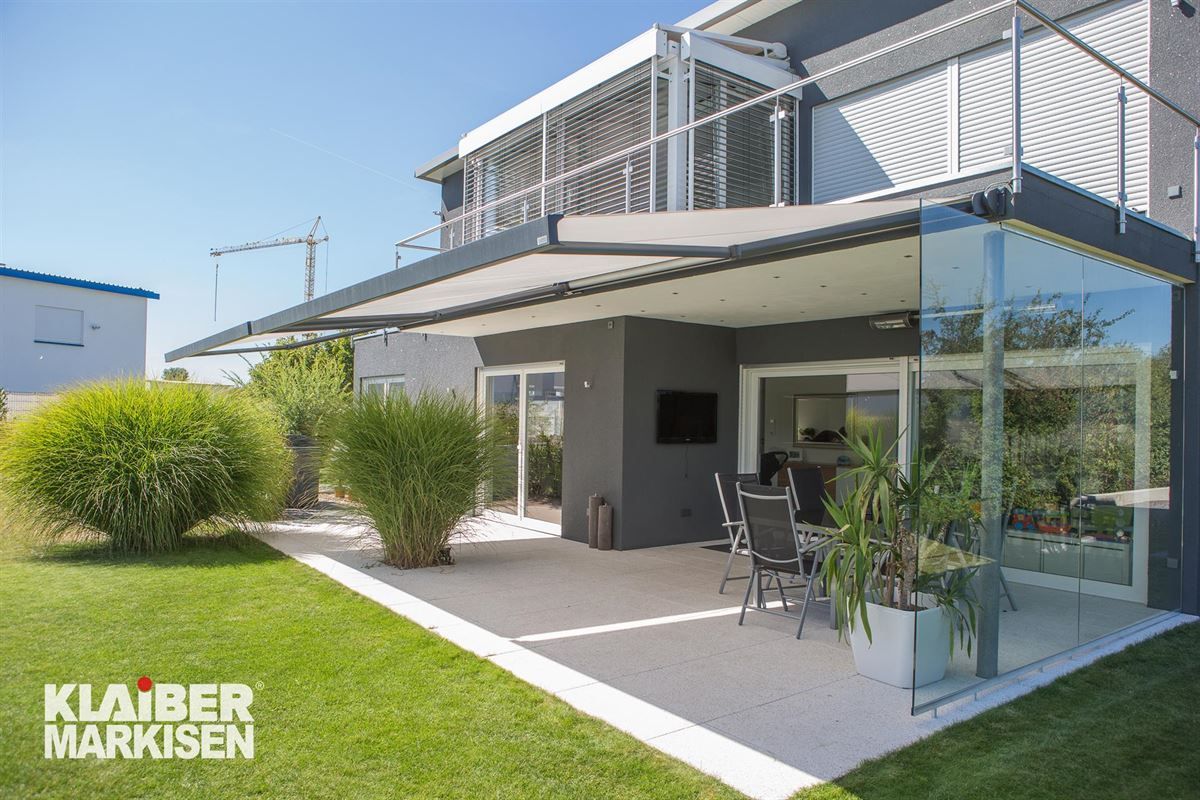 Ein großes Haus mit Terrasse und Balkon.
