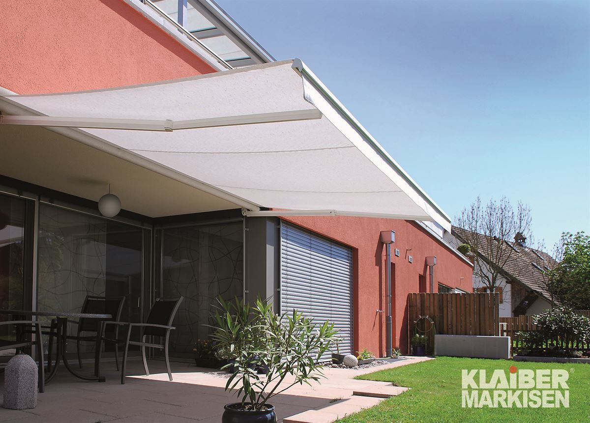 Ein rotes Haus mit einer weißen Markise an der Seite