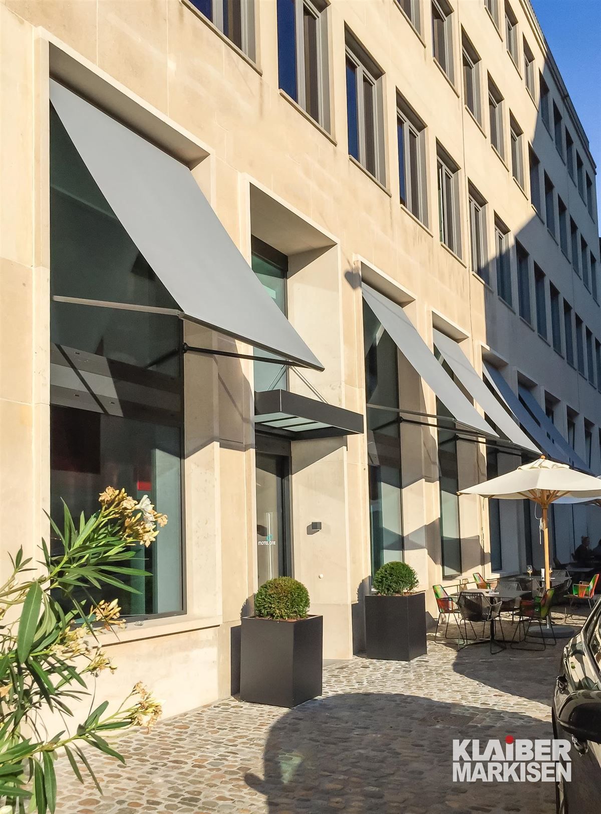 Ein Gebäude mit vielen Fenstern und Sonnenschirmen