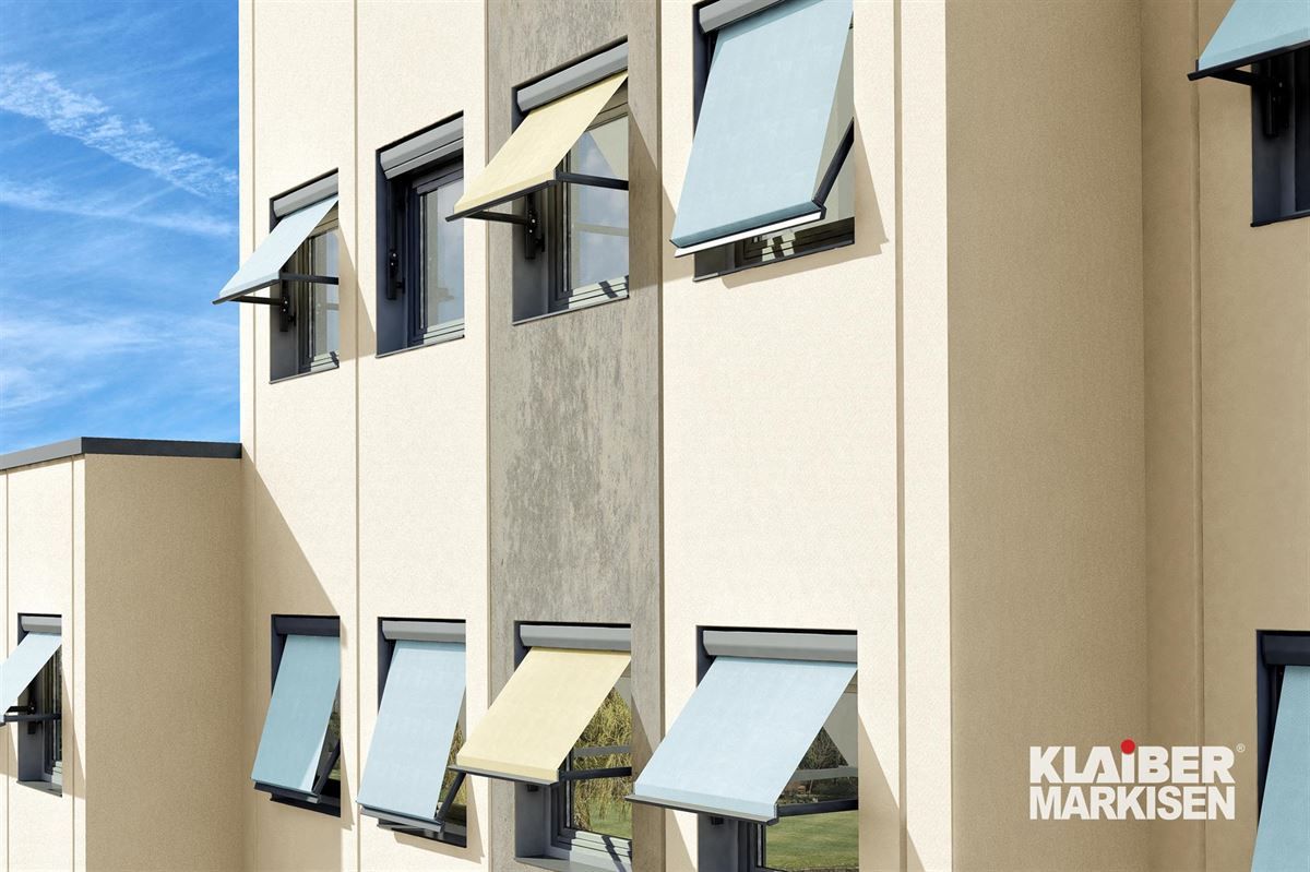 Ein Gebäude mit vielen Fenstern mit Markisen