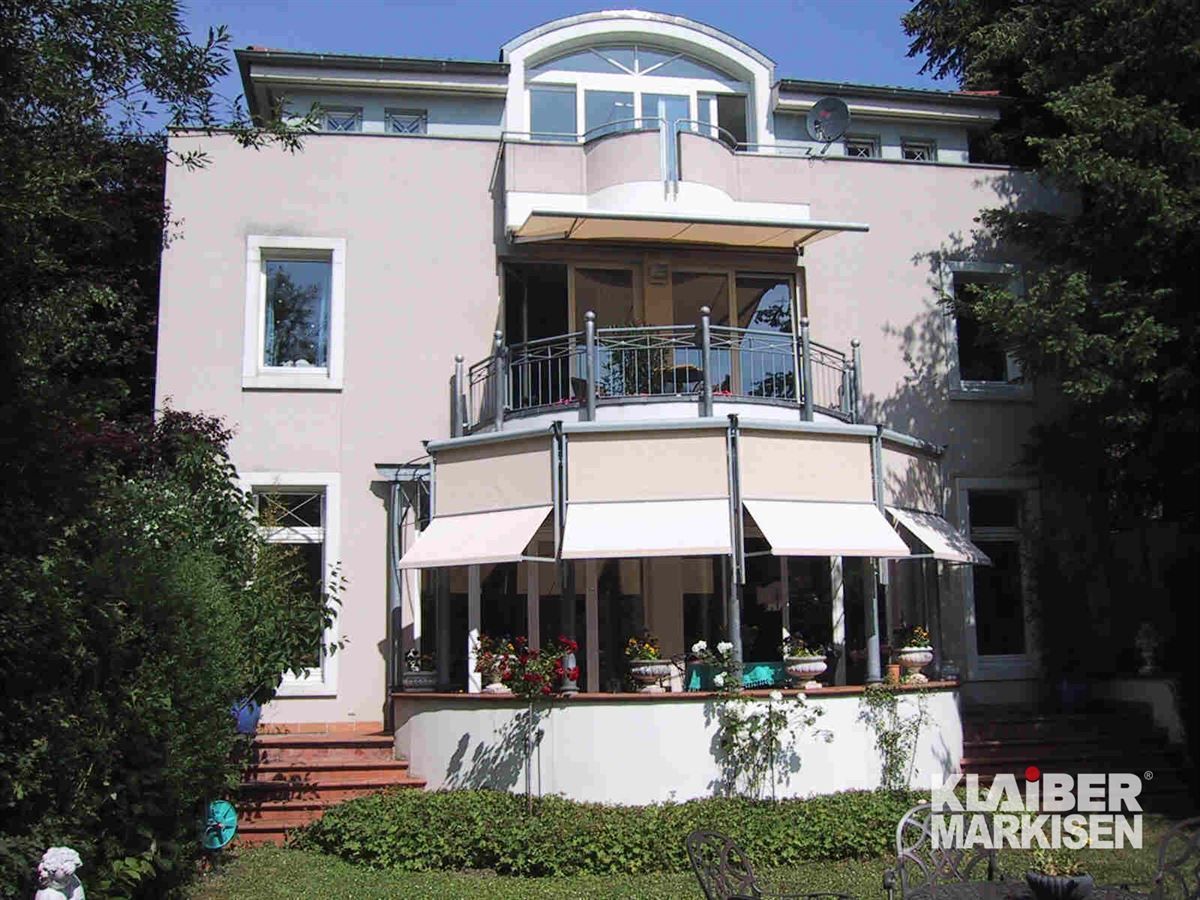 Ein großes Haus mit Balkon und einem Schild mit der Aufschrift Klaiber Markisen