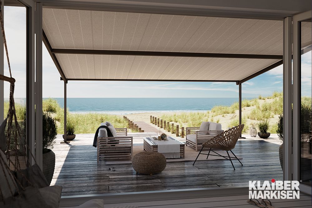 Eine Terrasse mit Pergola und Blick auf das Meer.