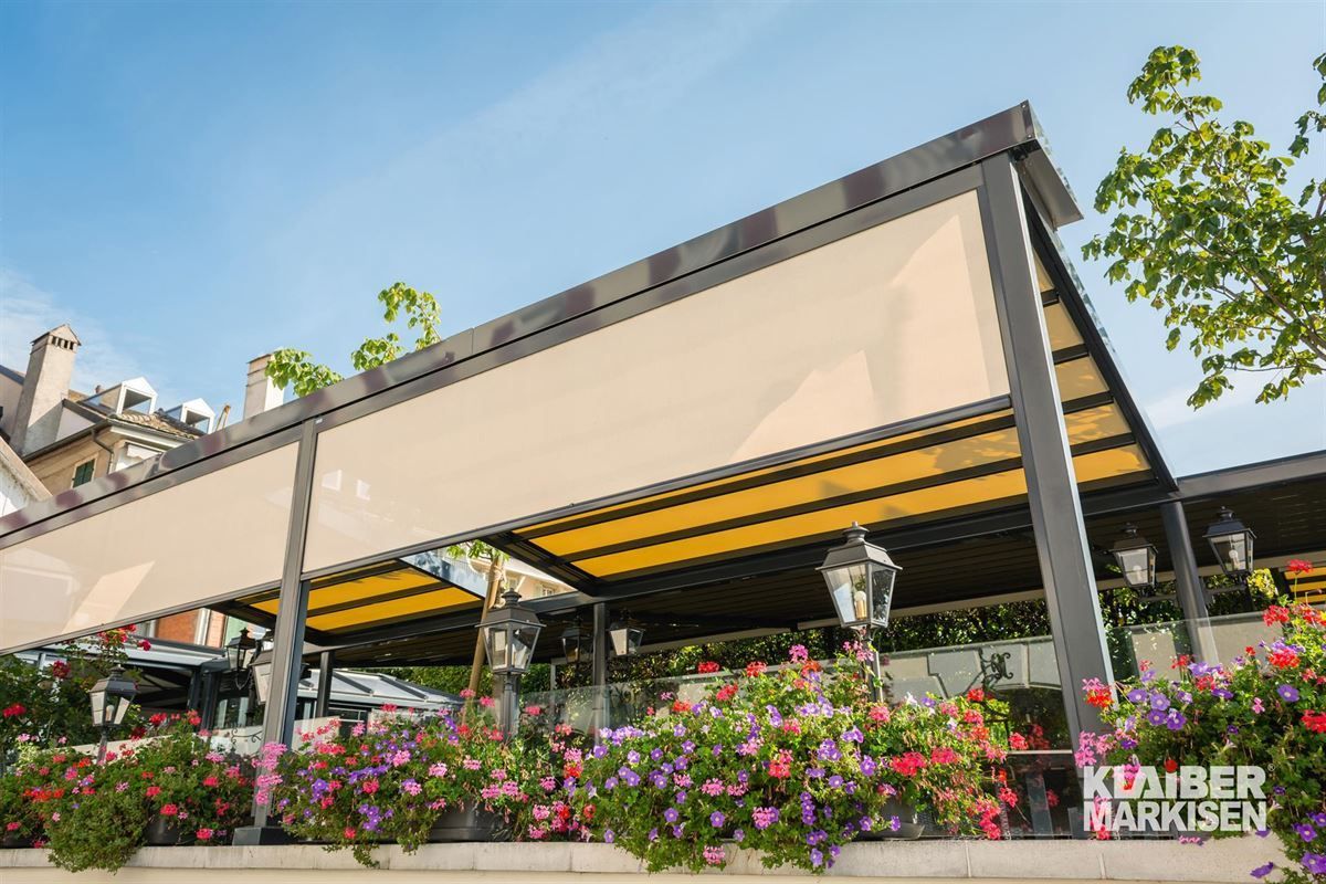 Ein Restaurant mit einem Baldachin und Blumen davor