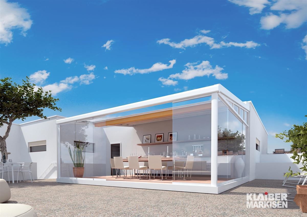 Eine künstlerische Darstellung eines weißen Hauses mit einem Esstisch und Stühlen.