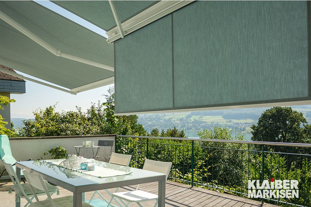 Eine Terrasse mit Tisch und Stühlen unter einer Markise.