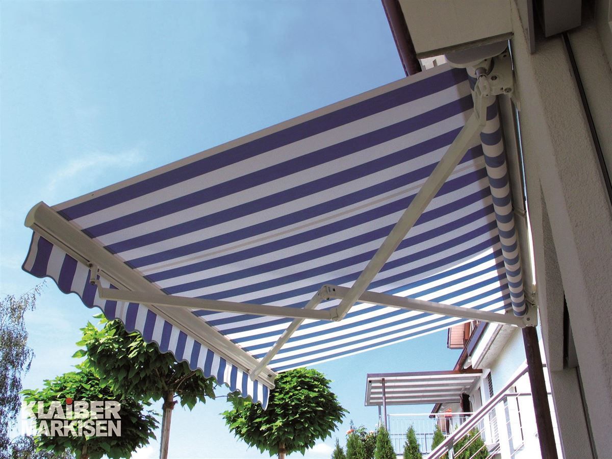 Eine blau-weiß gestreifte Markise befindet sich an der Seite eines Gebäudes