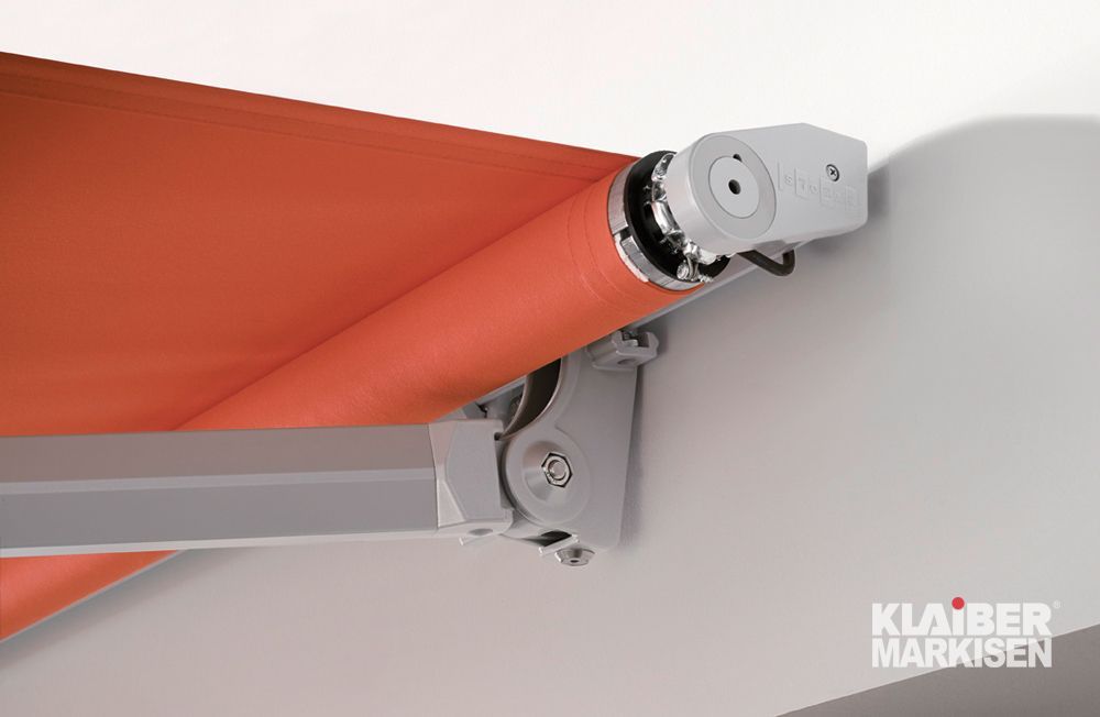 Eine Nahaufnahme einer orangefarbenen Markise an einer weißen Wand.