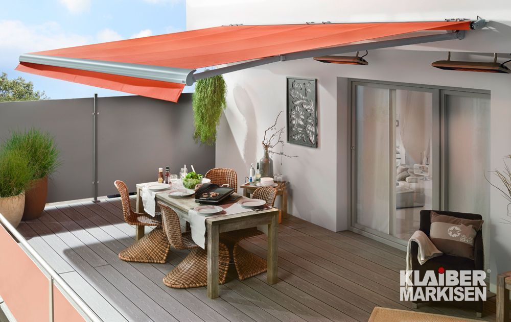 Eine Terrasse mit Tisch und Stühlen unter einer Markise.