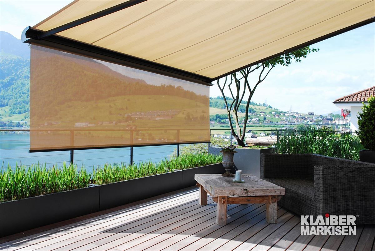 Eine Terrasse mit Tisch und Stühlen unter einer Markise.