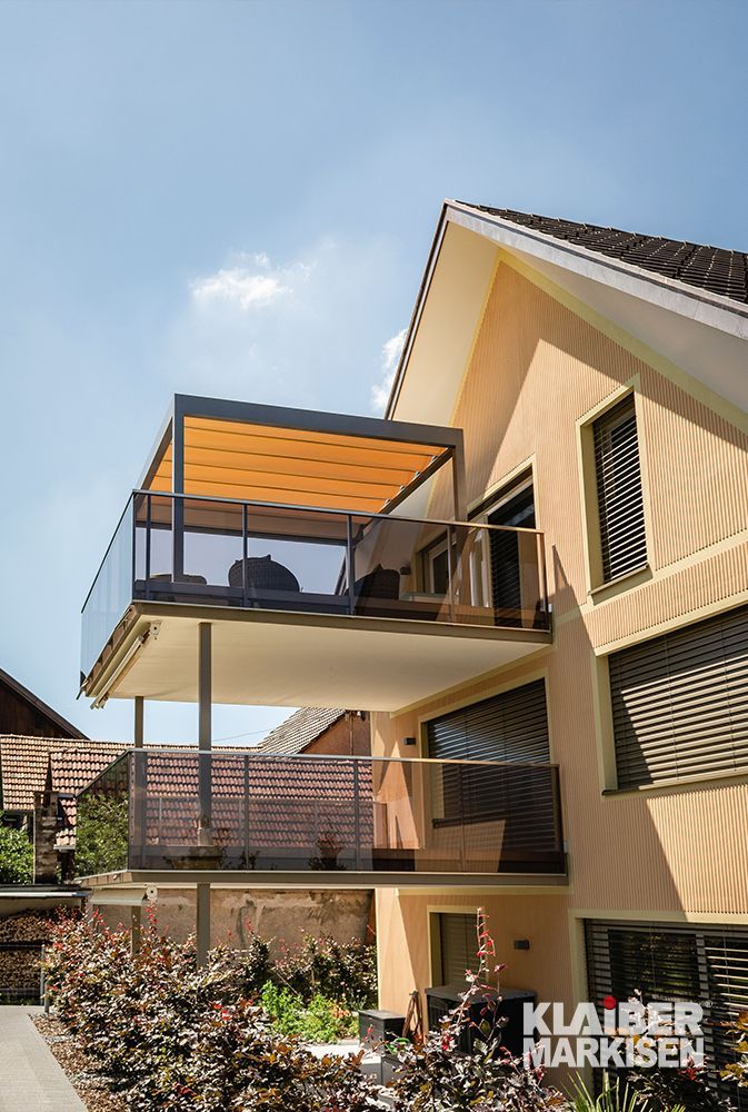 Ein Haus mit einem Balkon, der von einem Baldachin überdacht ist.