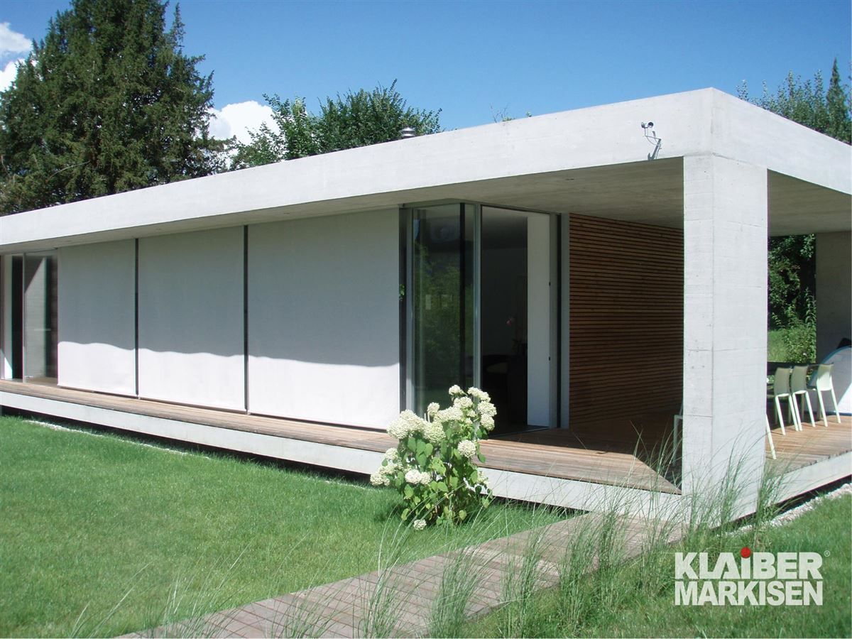 Ein großes weißes Haus mit einem Schild mit der Aufschrift Klaiber Markisen