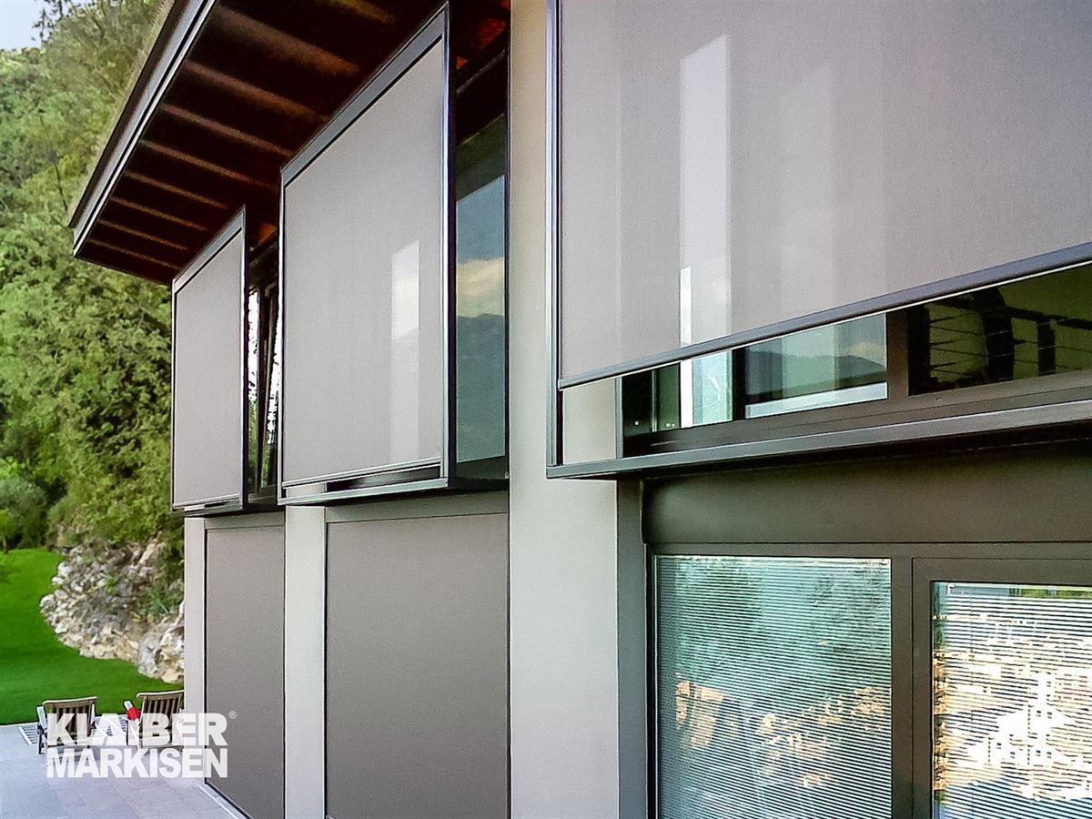 Ein Haus mit vielen Fenstern und Jalousien.