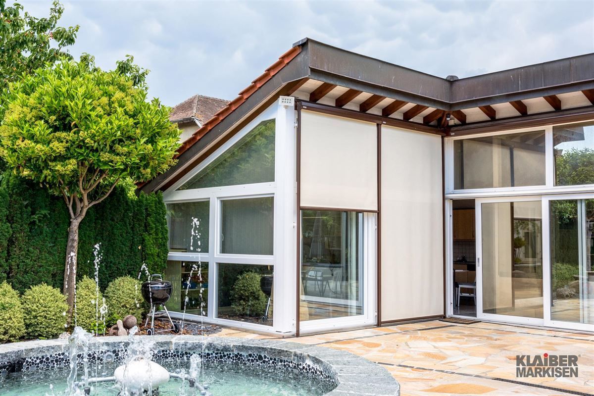 Ein großes Haus mit einem Brunnen davor.