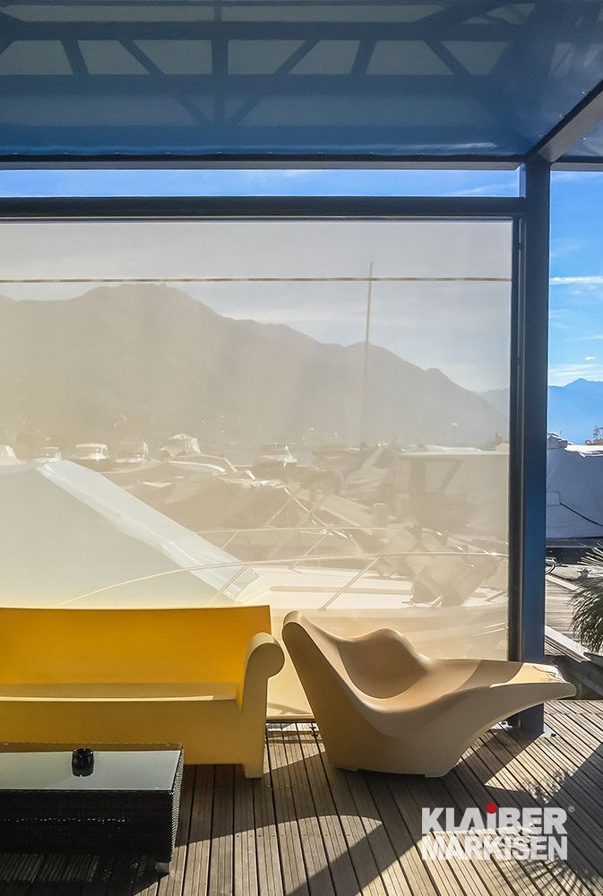 Ein Wohnzimmer mit einer gelben Couch und Stühlen und Blick auf die Berge.