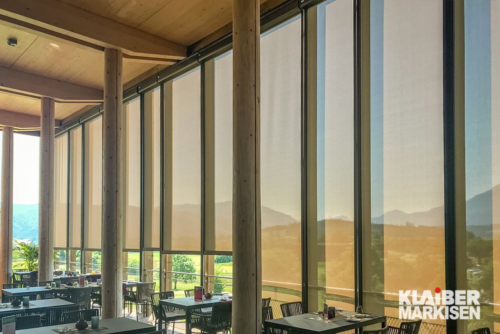 Ein Restaurant mit Tischen und Stühlen vor einem großen Fenster.