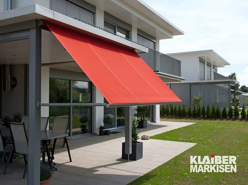 Ein Haus mit einer roten Markise an der Seite