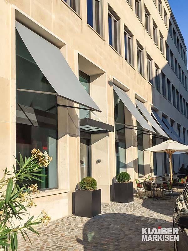 Ein Gebäude mit vielen Fenstern und Sonnenschirmen