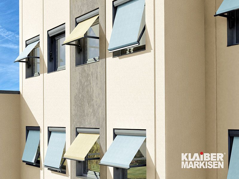 Ein Gebäude mit vielen Fenstern mit Markisen