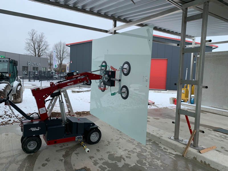 Ein großes Stück Glas wird von einer Maschine angehoben.