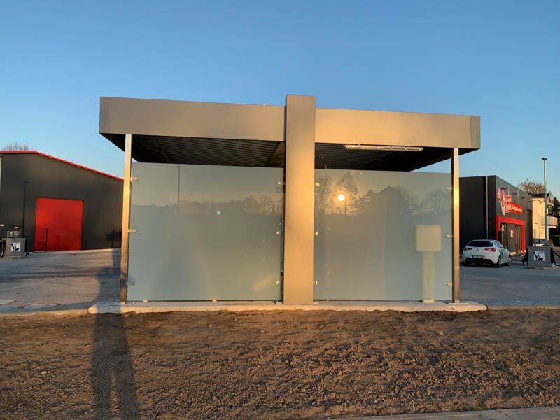 Ein Gebäude mit einer Glaswand und einem davor geparkten Auto.