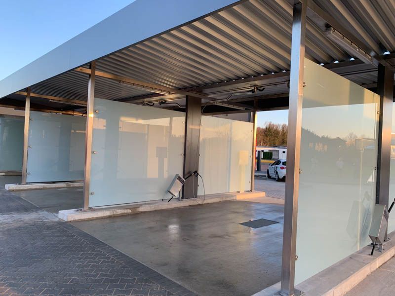 Ein Auto ist unter einem Vordach einer Autowaschanlage geparkt