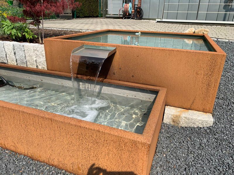 In der Mitte eines Teichs befindet sich ein Wasserfall.