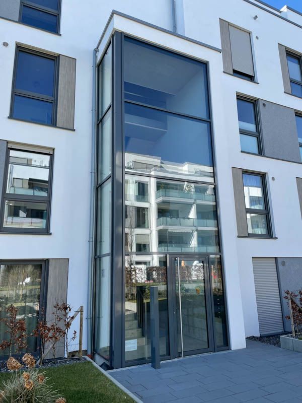 Ein Gebäude mit vielen Fenstern und einer großen Glastür