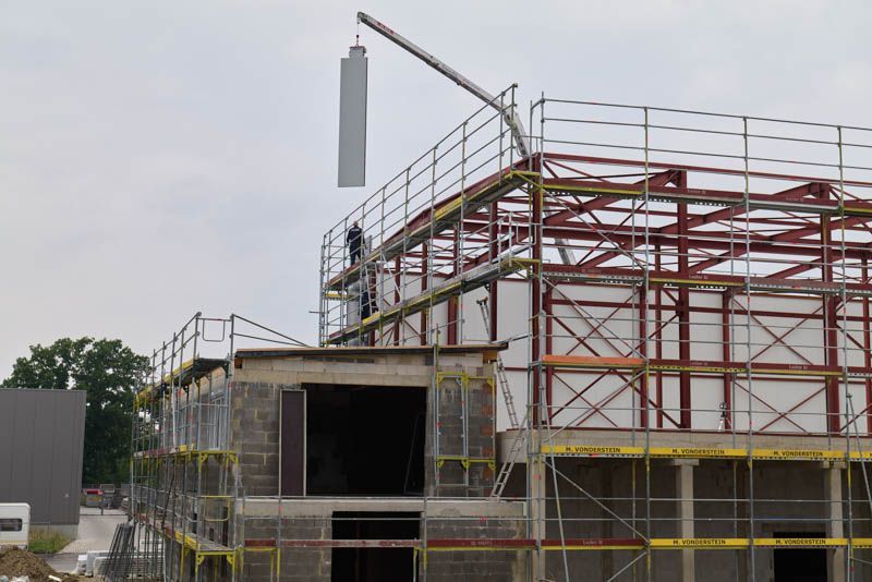 Es wird ein Gebäude errichtet, das von einem Gerüst umgeben ist.